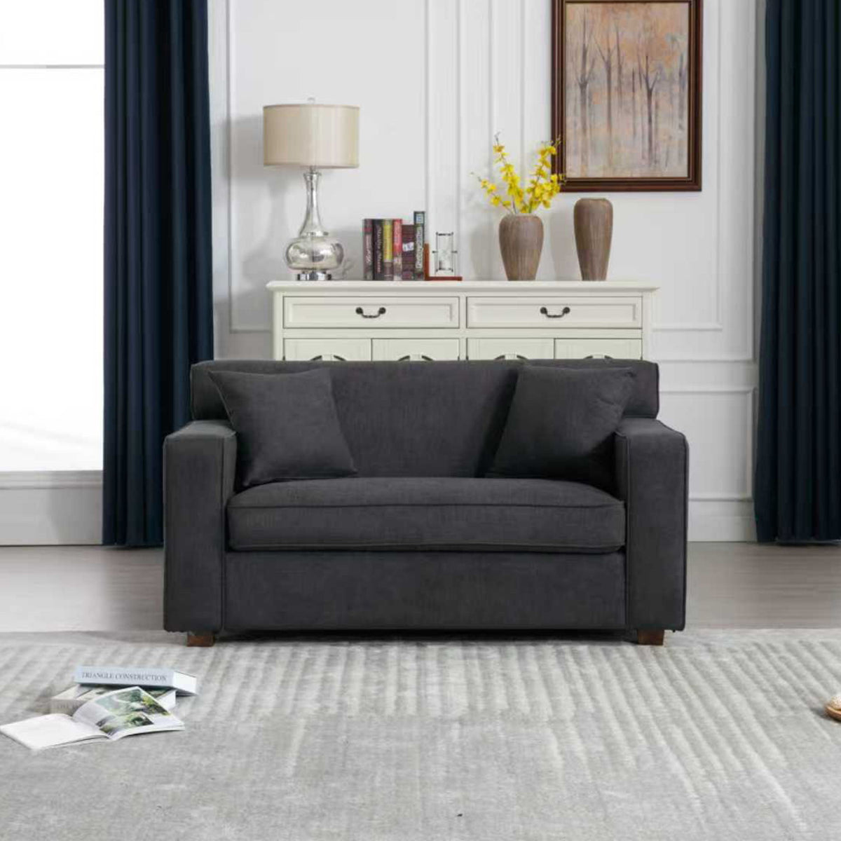 Gray lounge chair seating with two throw pillows and padded armrests