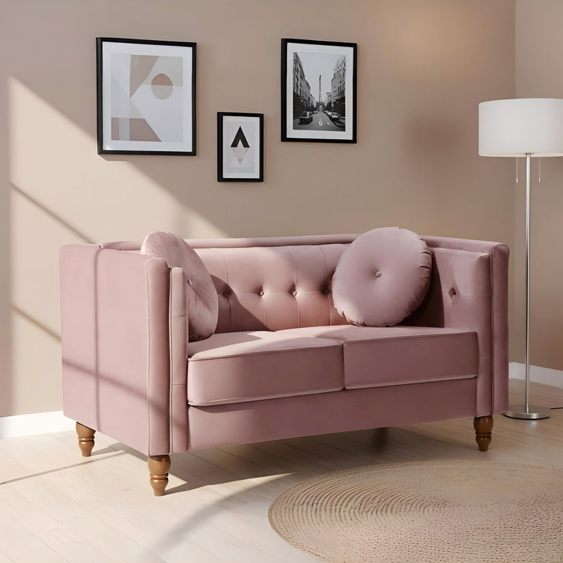 Pink tufted 2-seater loveseat with round arm cushions and button-tufted back and seat.