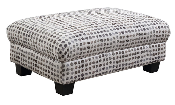 Fabric ottoman with tufted top, white base and dark ink-dot pattern, square legs