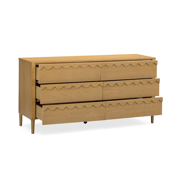 Light brown 6-drawer dresser with wavy drawer fronts and tapered legs, angled view