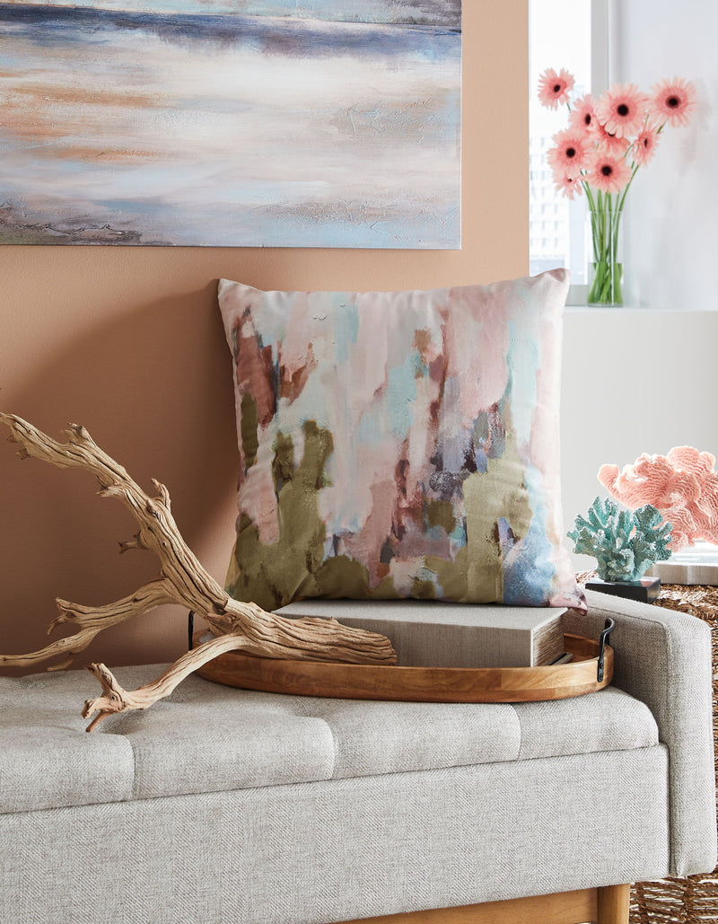 Abstract watercolor decorative pillow in pastel pink, blue, and green on a sofa