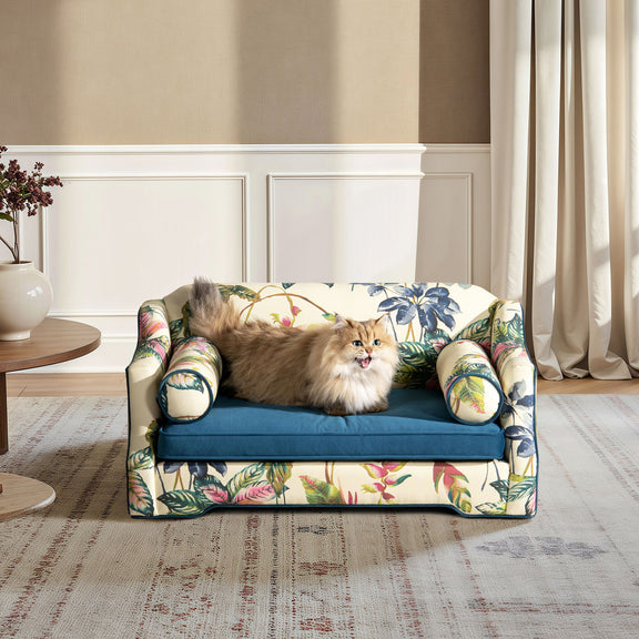 Botanical floral dog sofa bed cover with blue base, rounded arm bolsters, and bolster pillows