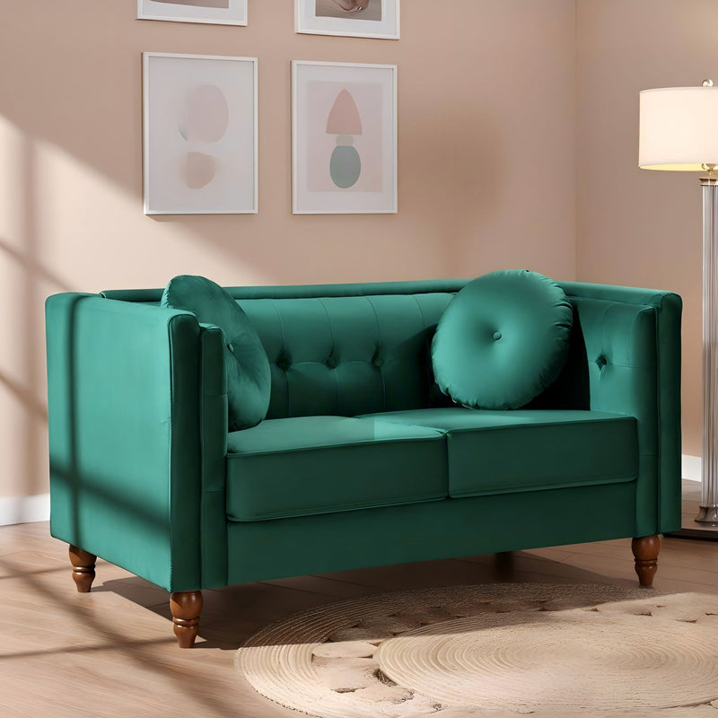Green tufted 2-seater loveseat with round arm cushions and large round back pillows.