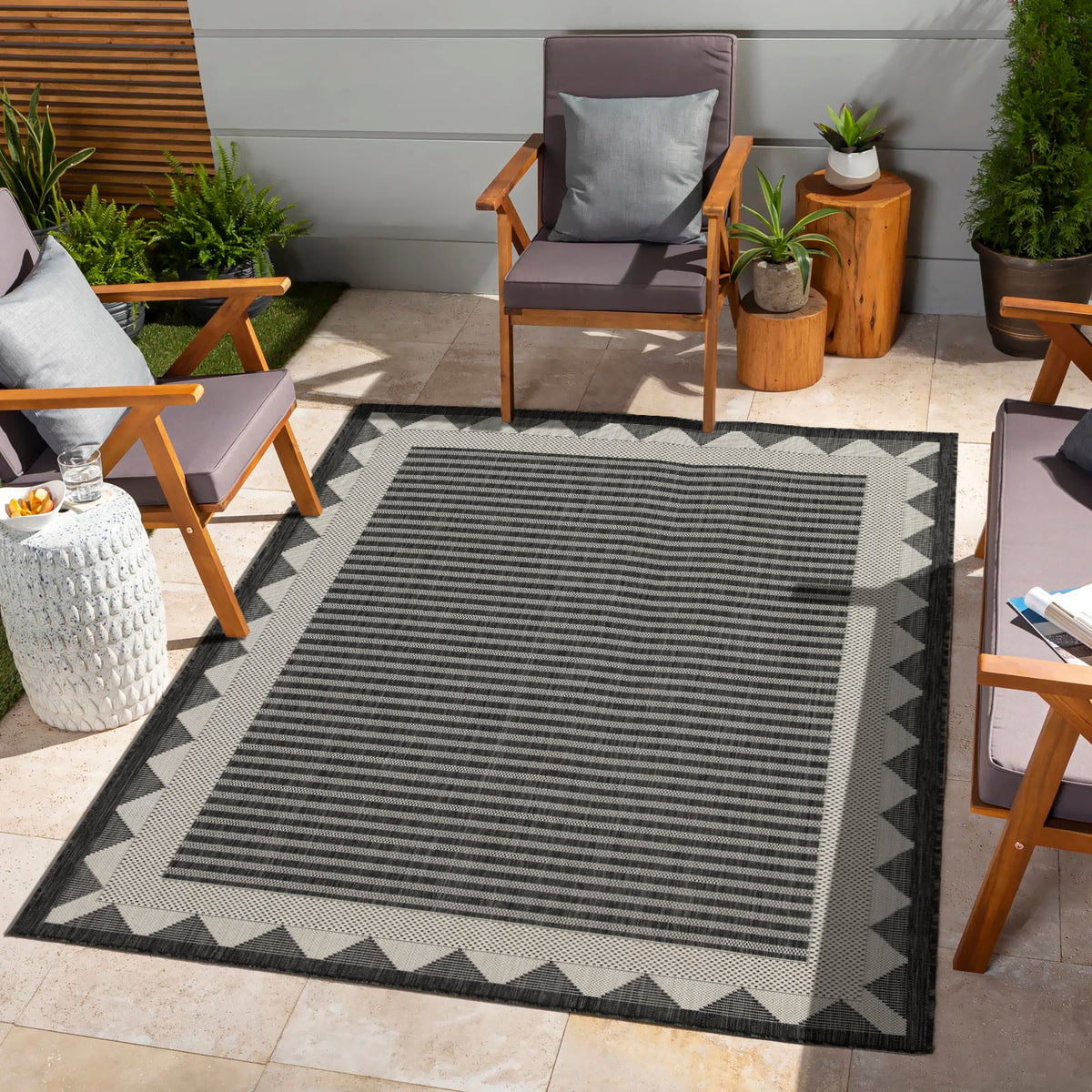 Dark gray striped area rug with zigzag border and geometric corner trim
