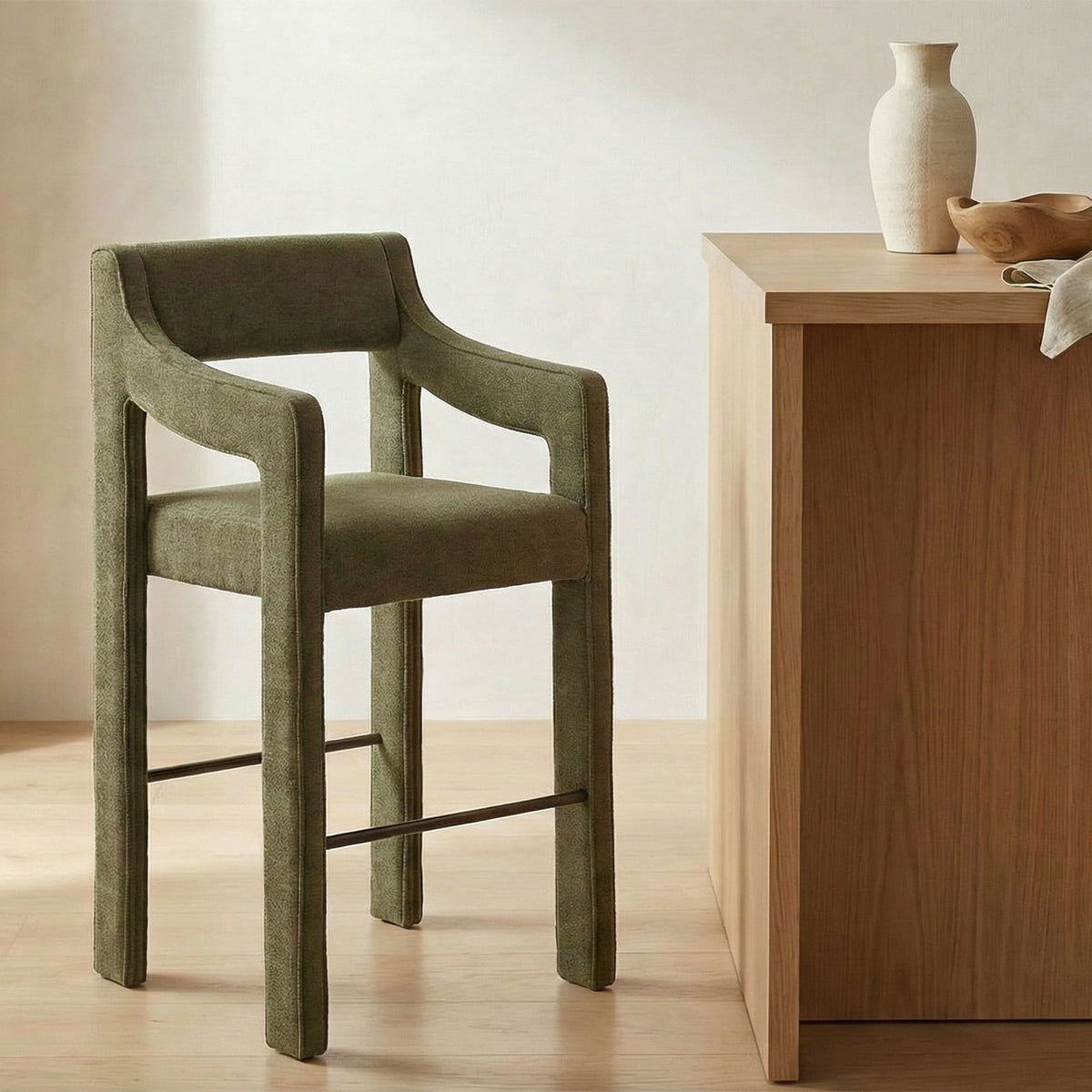Cedar green upholstered counter stool with wide armrests, wood frame, and footrest bar