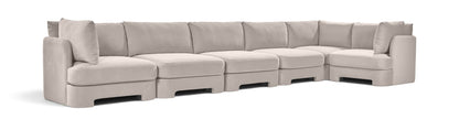 Light gray velvet L-shaped sectional sofa with tufted cushions and boxed arms.