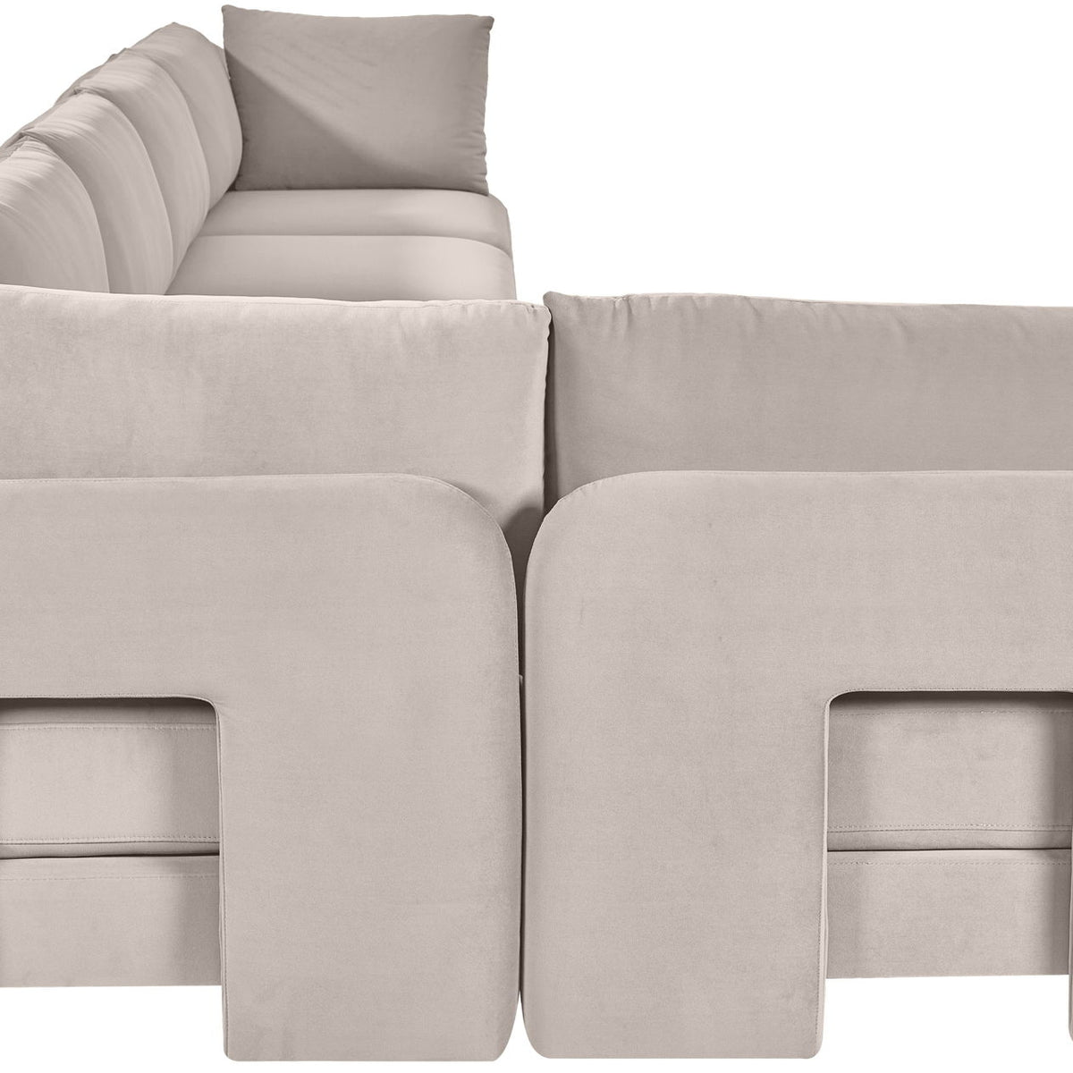 Light gray armless sectional sofa with square front panel detailing and back pillows