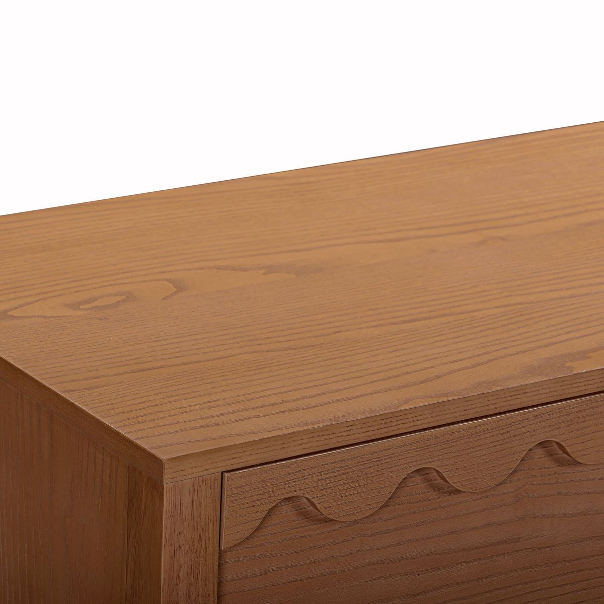 Close-up of dark brown wood dresser top and wavy drawer front details