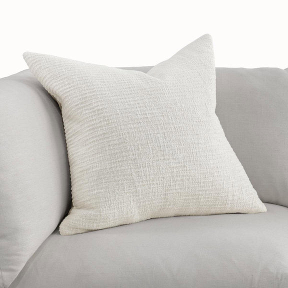 Ivory woven throw pillow with textured fabric and squared corners on a sofa