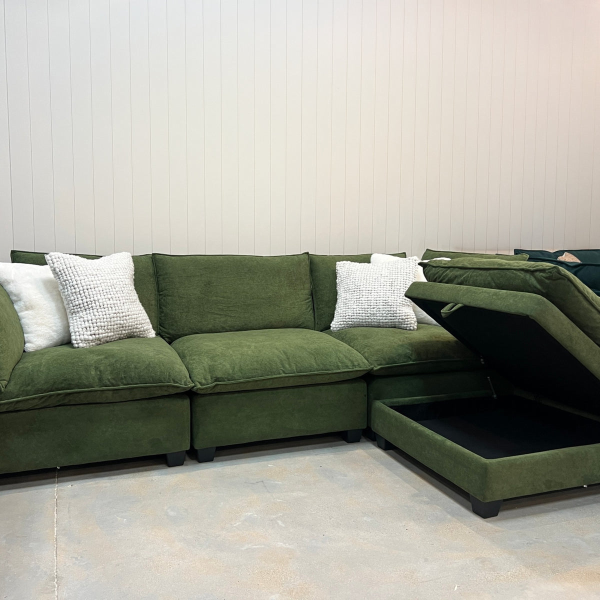 Olive green modular sectional sofa with corner chaise and white throw pillows