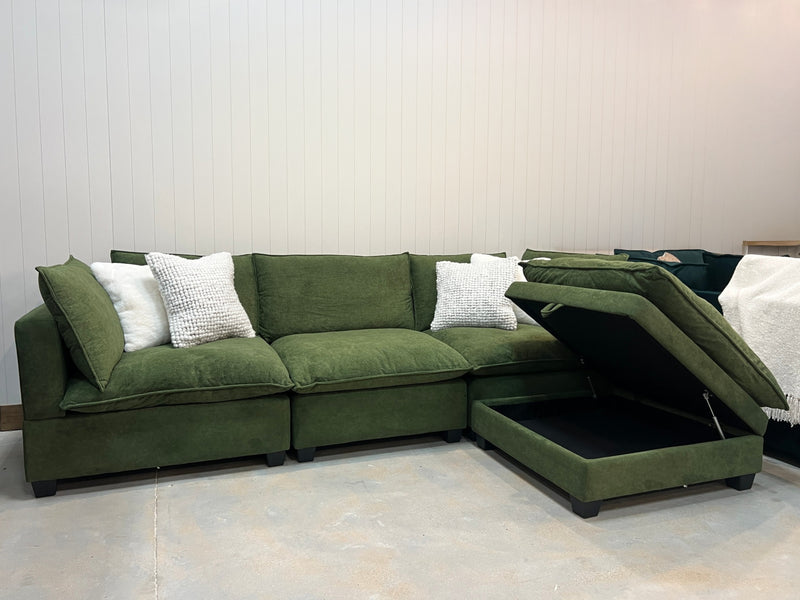 Olive green modular sectional sofa with corner chaise and white throw pillows