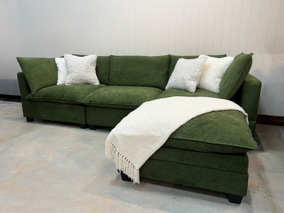Olive green modular sectional sofa with chaise extension and white knit throw