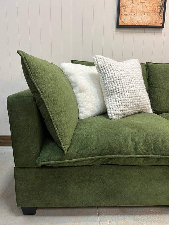 Olive green modular sectional sofa with side arm and white textured throw pillows