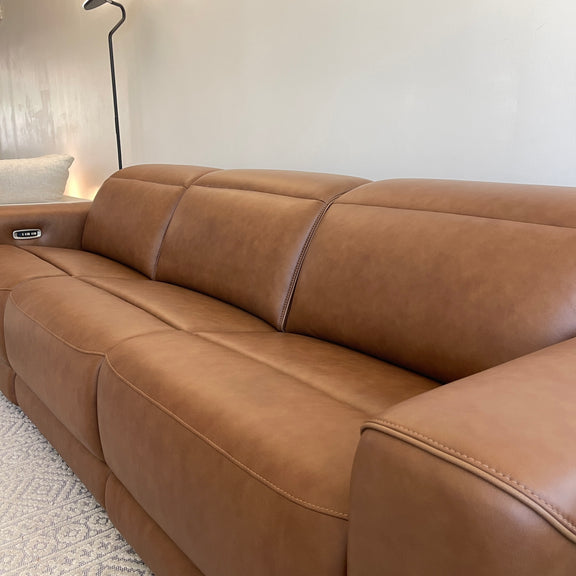 Caramel leather power reclining sectional sofa with smooth seat cushions and curved armrest