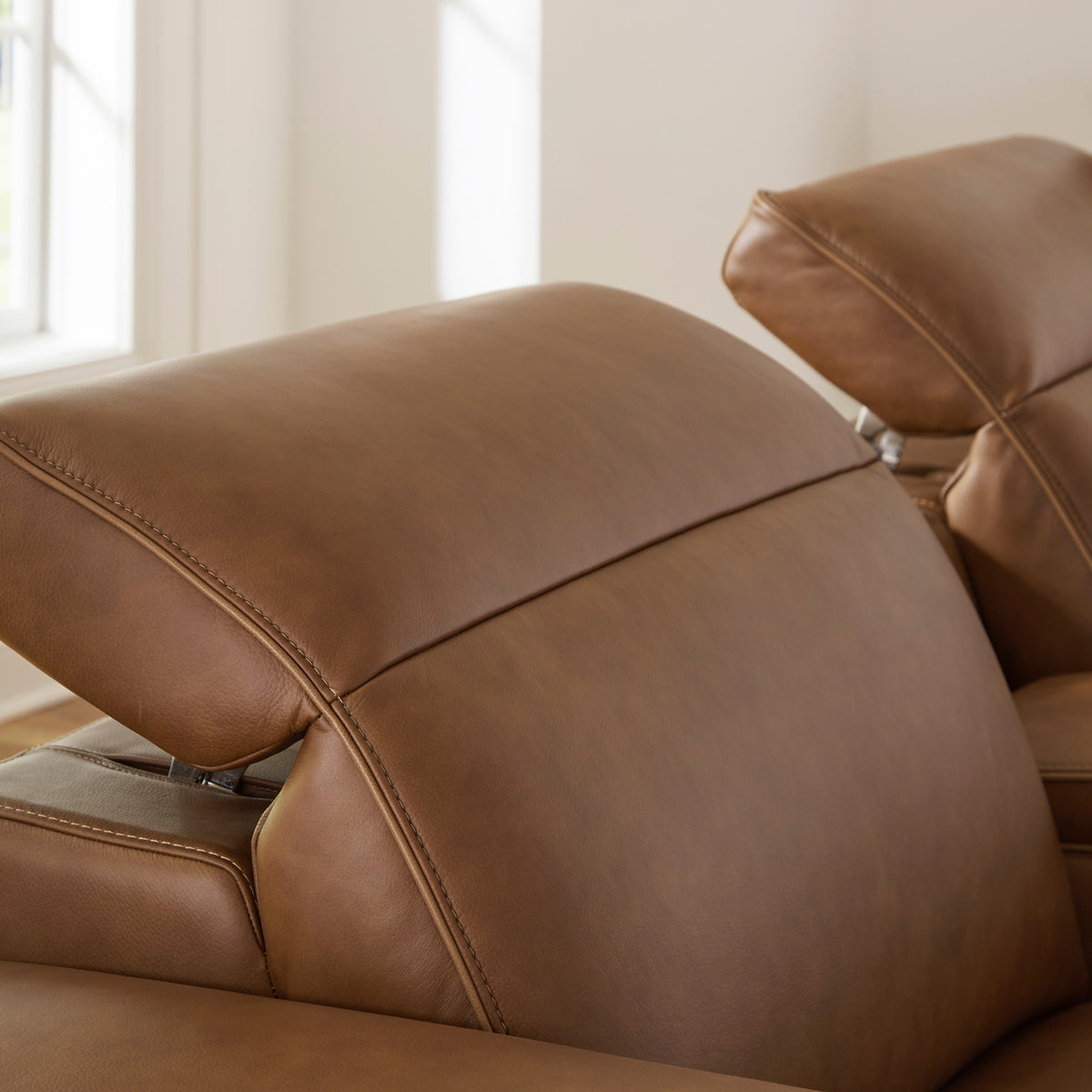 Caramel leather power recliner with padded headrest and reclined backrest