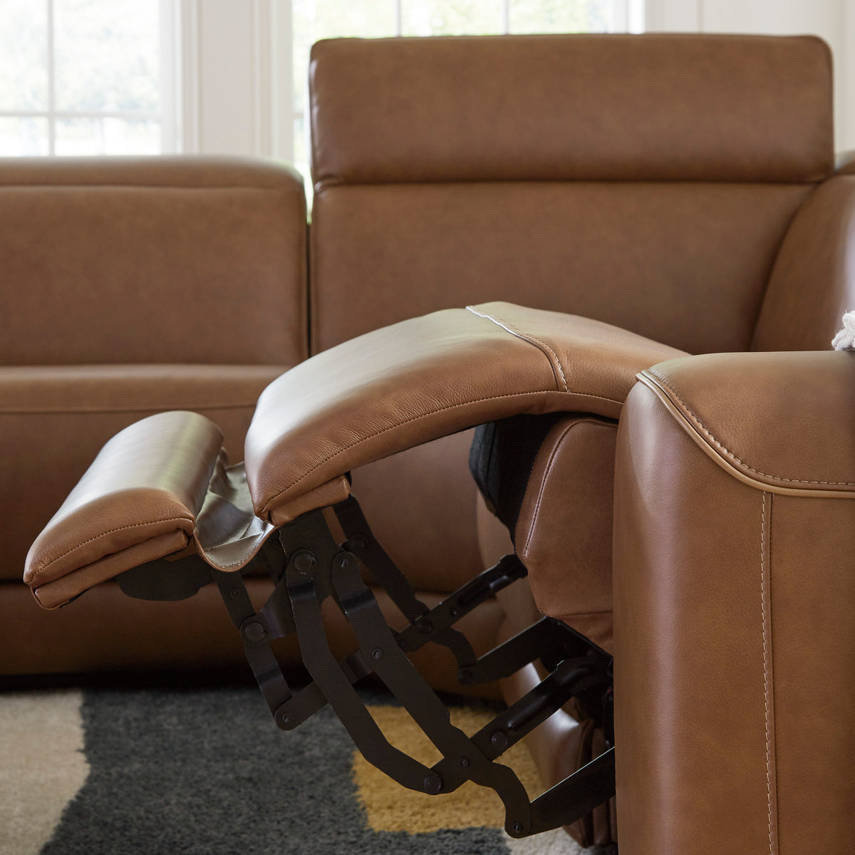 Caramel leather power reclining sectional with open recline mechanism and padded arms