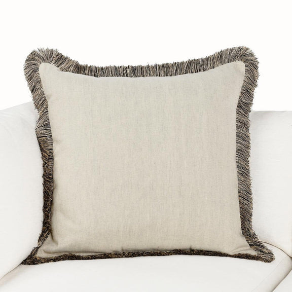 Natural linen square pillow with dark gray fringe, shown on a sofa