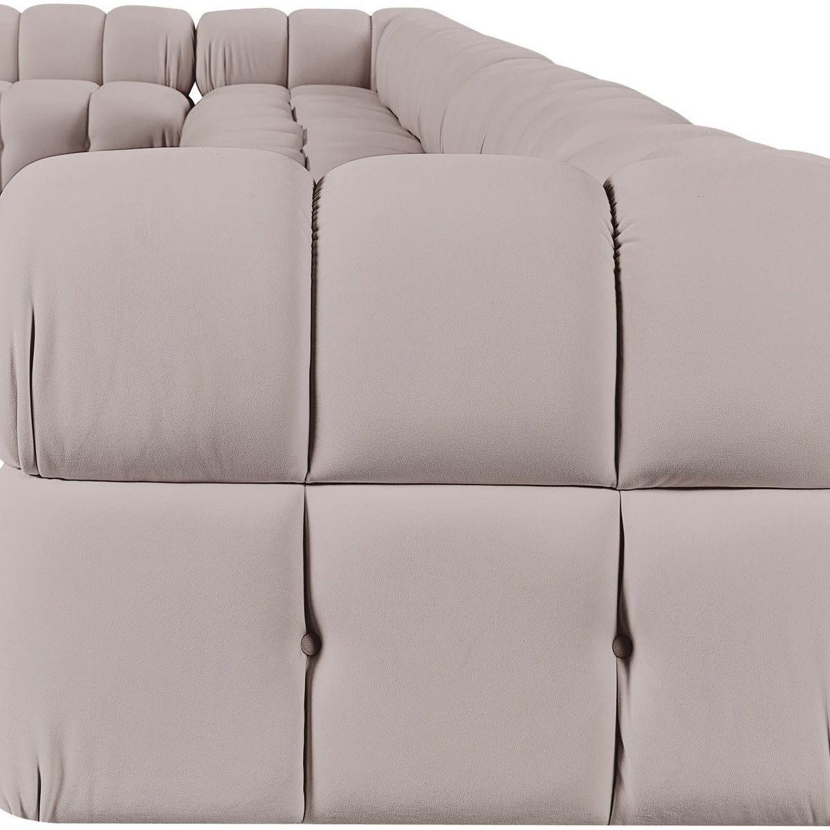 Light beige velvet L-shaped sectional sofa with tufted cushions and rounded arms.