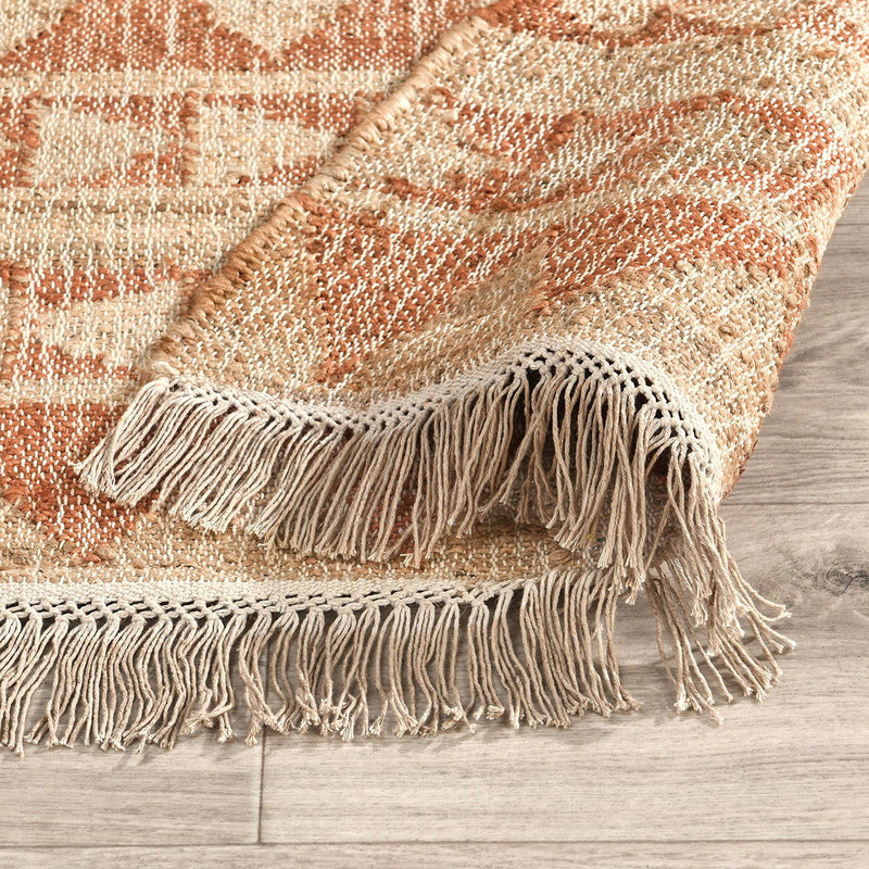 Solana rug in distressed terracotta and natural with textured weave and fringed edges.