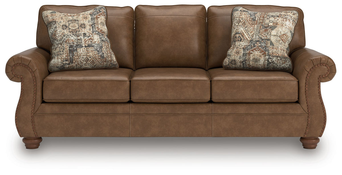 Brown sofa with three seat cushions and two patterned throw pillows