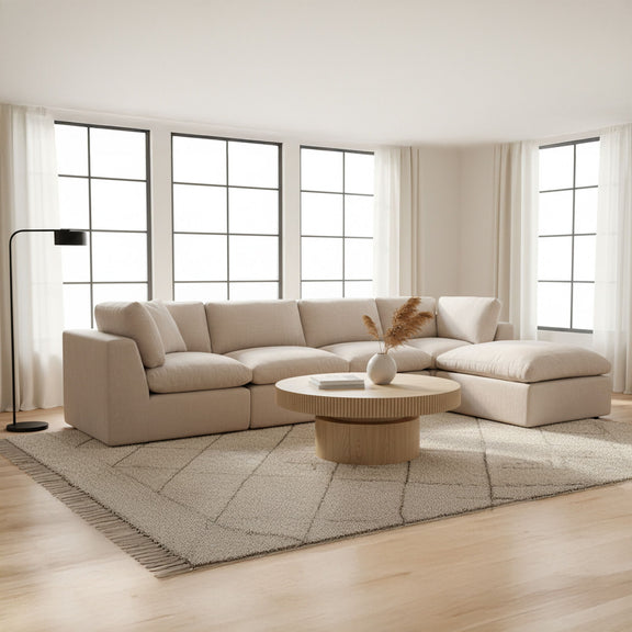 Beige modular sectional sofa with chaise section and multiple seat cushions, clean arm design