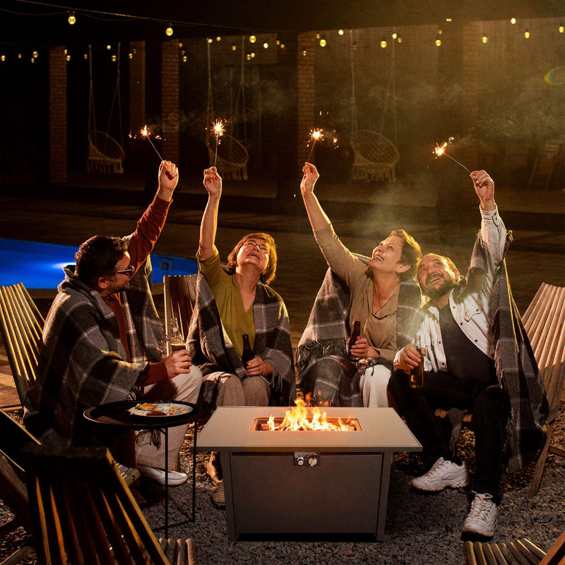 Black fire pit table in outdoor setting with open flames and lid on