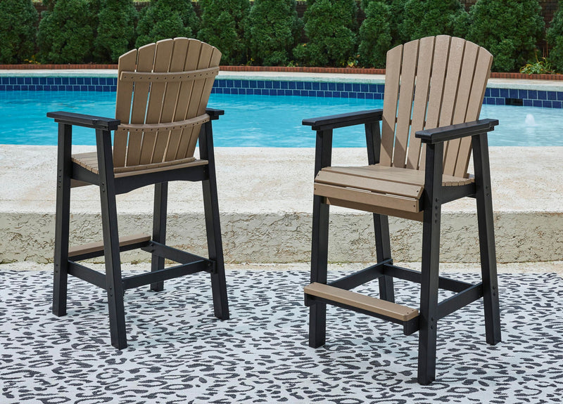 Outdoor tall barstool set with dark frame, driftwood slat backs, and cushioned seats