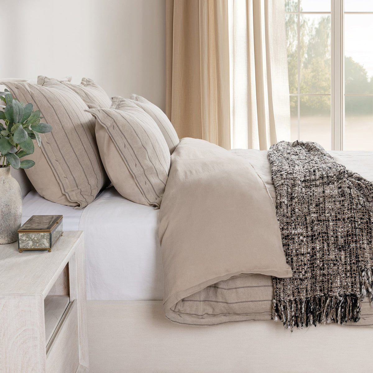 Beige duvet cover with subtle stripe pattern on a bed