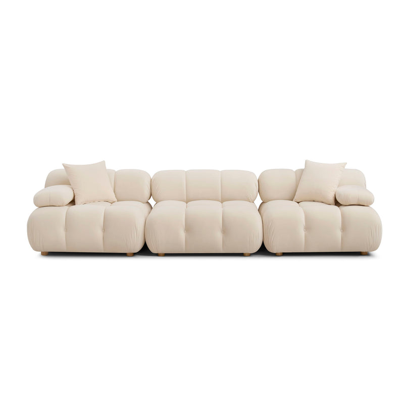 Light cream modular sofa with padded arms, tufted sections, and square base