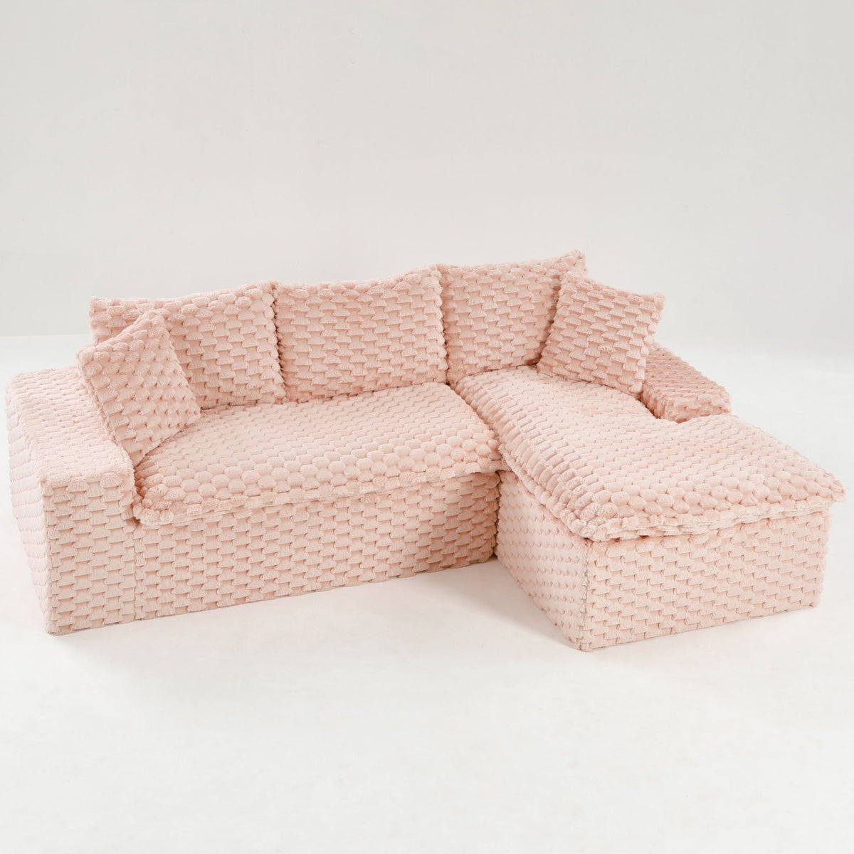 Pink modular sofa with chaise lounge, textured woven upholstery and padded cushions