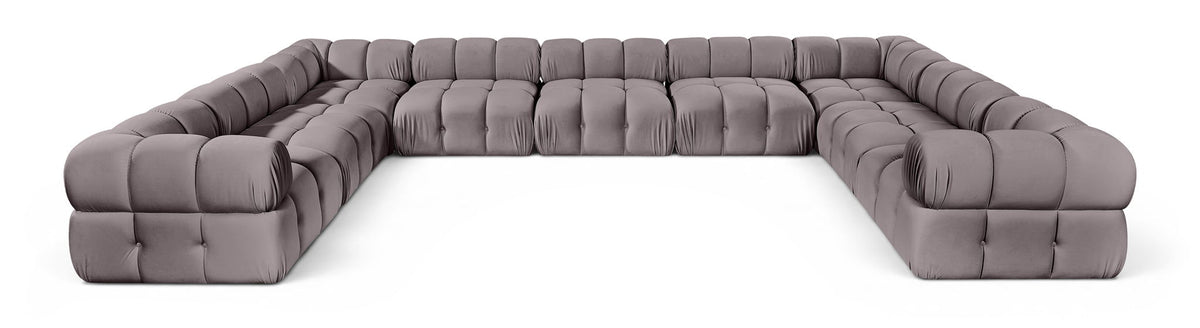 Light gray velvet upholstered sectional sofa with tufted seat and rounded armrests