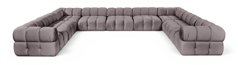 Light gray velvet upholstered sectional sofa with tufted seat and rounded armrests