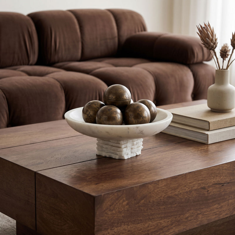 Genuine marble bowl centerpiece with white mottled basin and stacked pedestal on wooden coffee table.