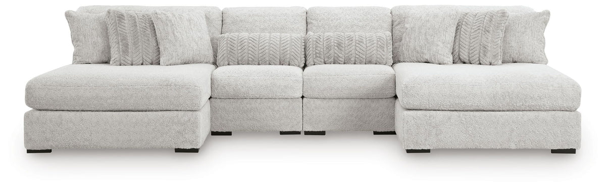 White sectional sofa with two ottomans and multiple cushion sections
