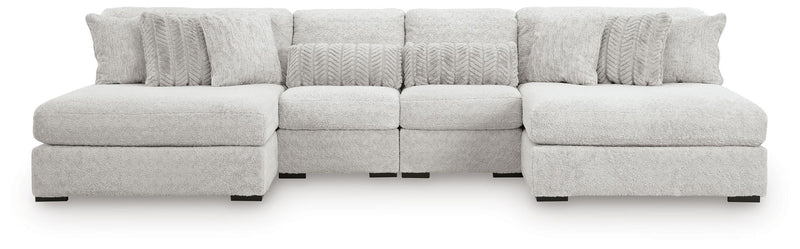 White sectional sofa with two ottomans and multiple cushion sections