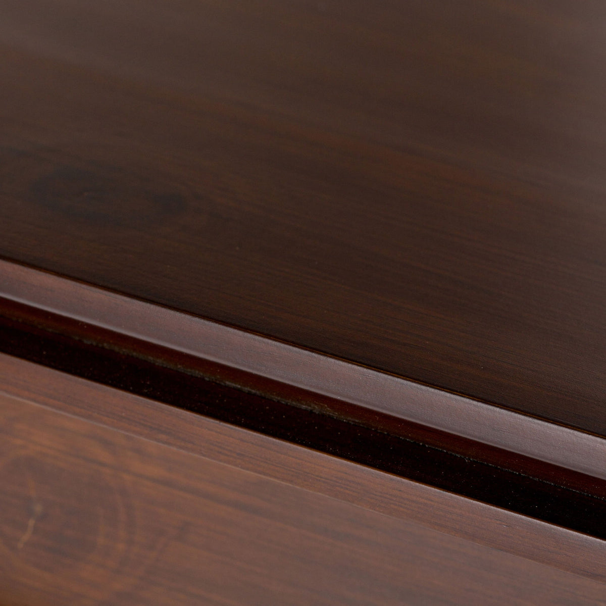 Wood storage cabinet trim detail with visible grain and layered molding