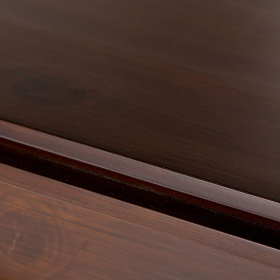 Wood storage cabinet trim detail with visible grain and layered molding