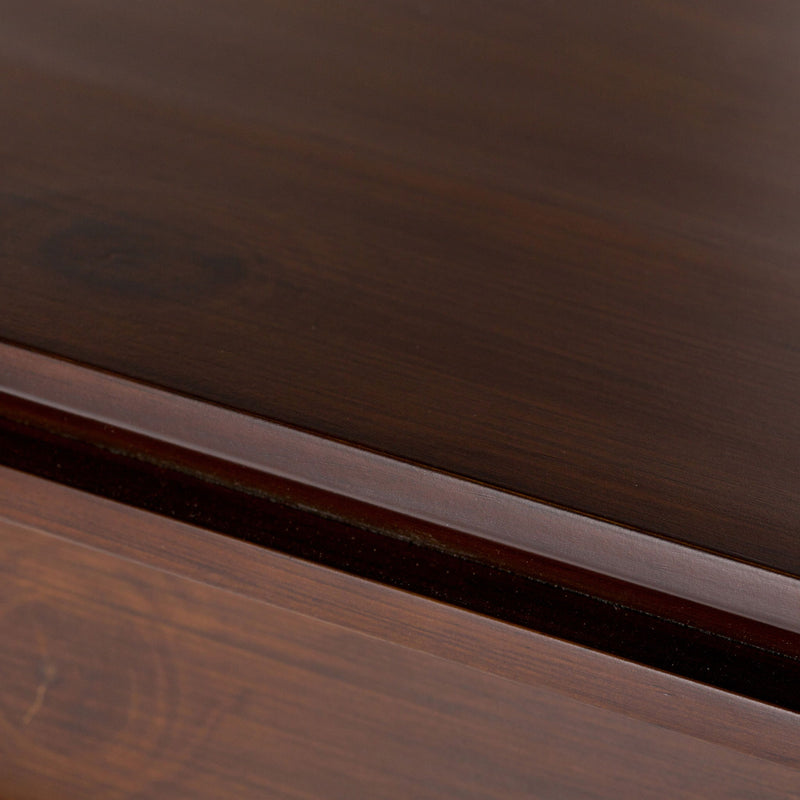 Wood storage cabinet trim detail with visible grain and layered molding