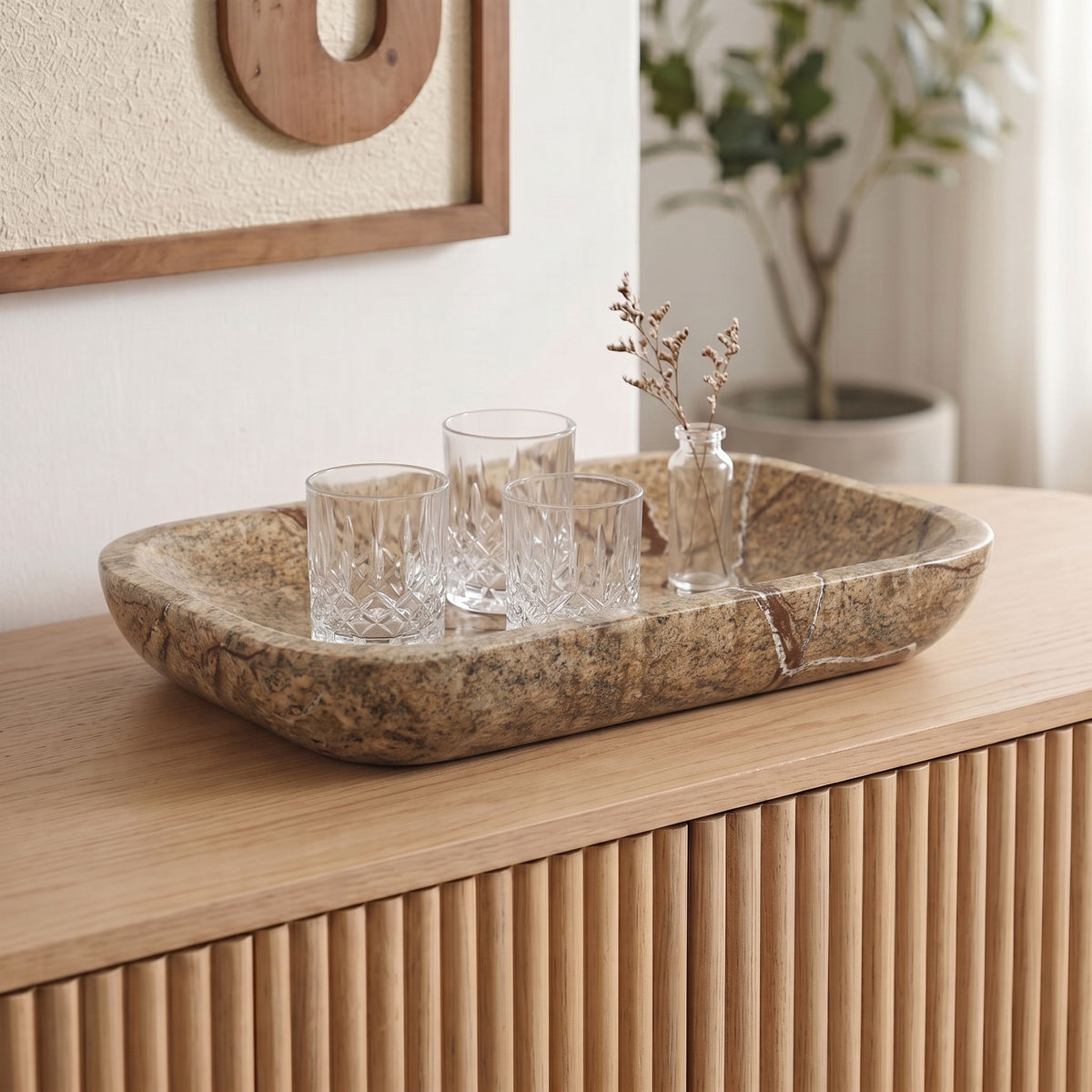 Marble serving tray with brown veining and a shallow oval form, used as a centerpiece