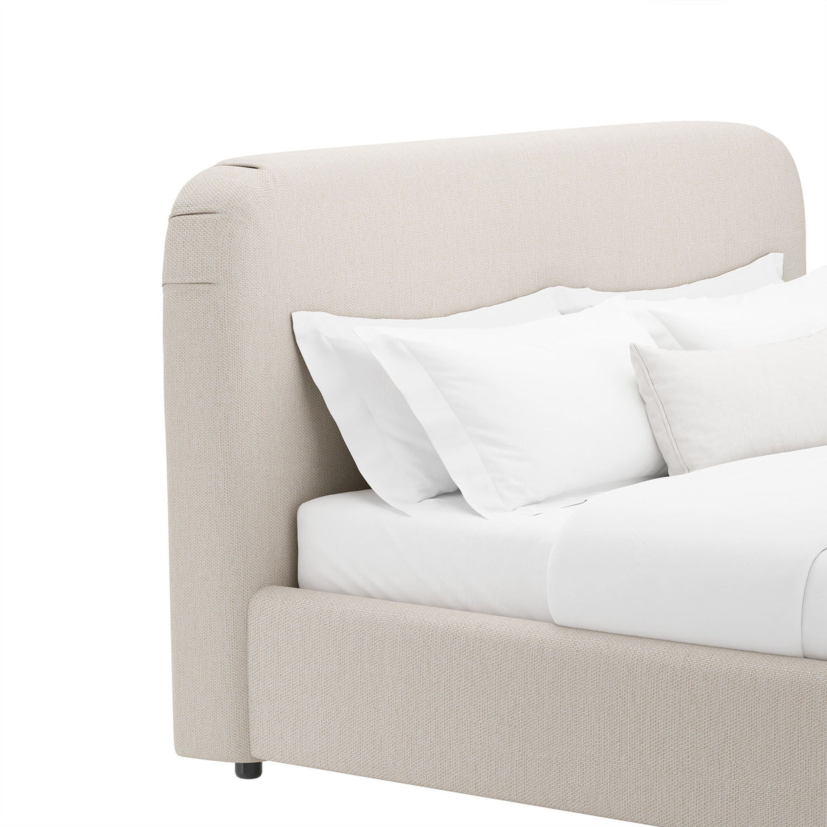 Beige rounded upholstered bed frame with curved headboard and layered white pillows