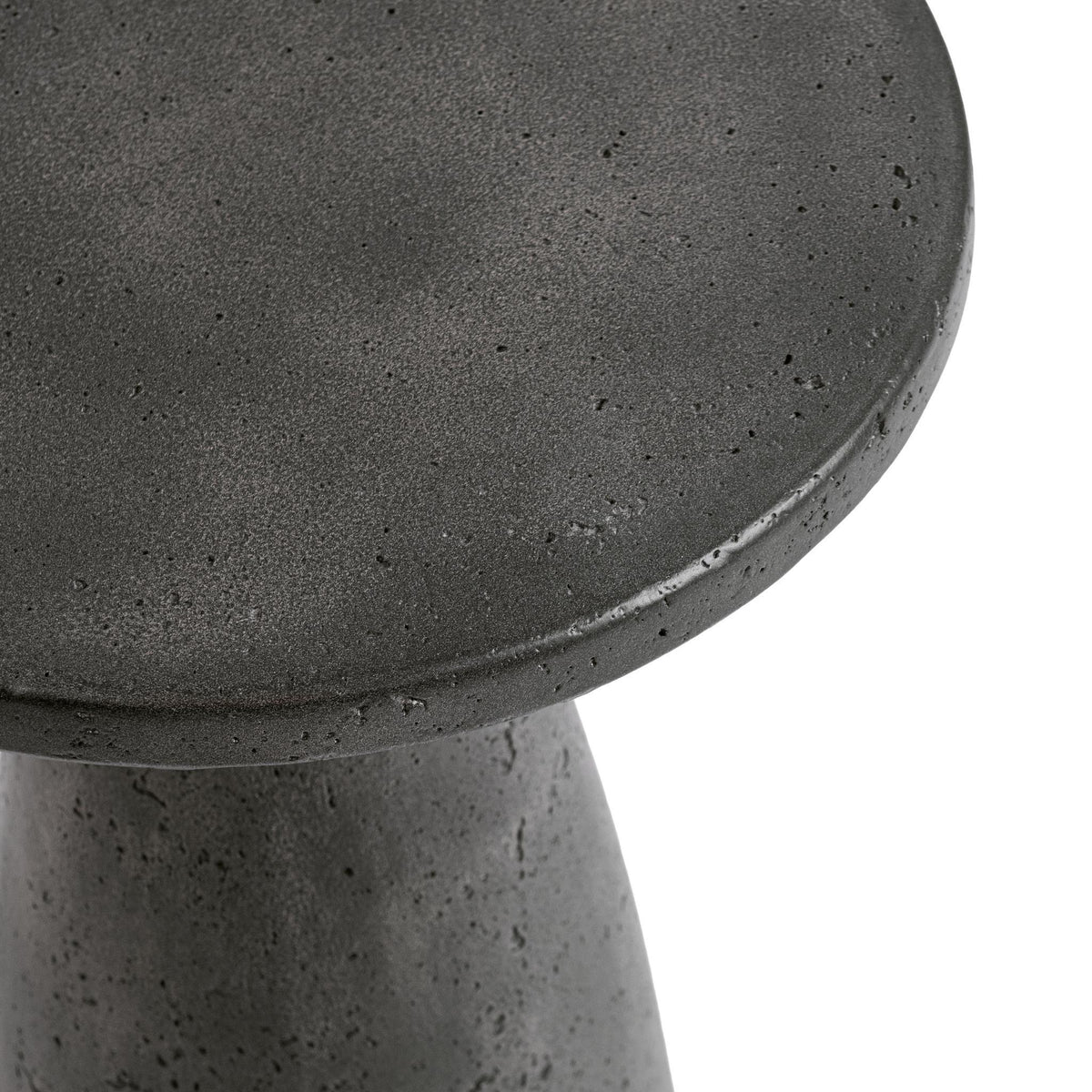 Outdoor accent table, dark gray speckled concrete round top edge close-up