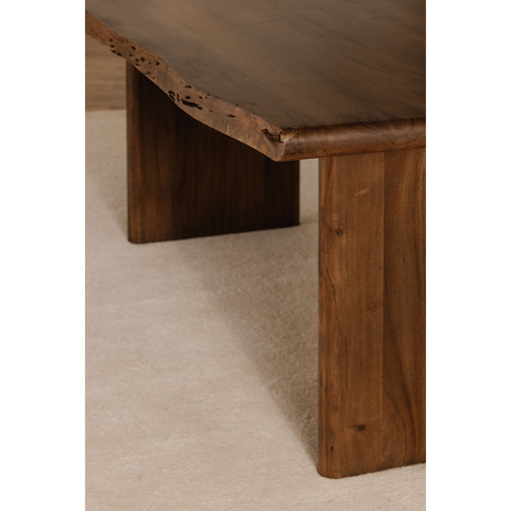 Small dining table corner detail: brown wooden legs and live-edge tabletop