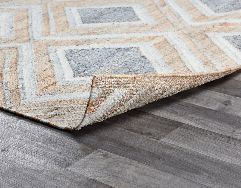 Geometric diamond rug corner with bound edge; textured low-pile surface
