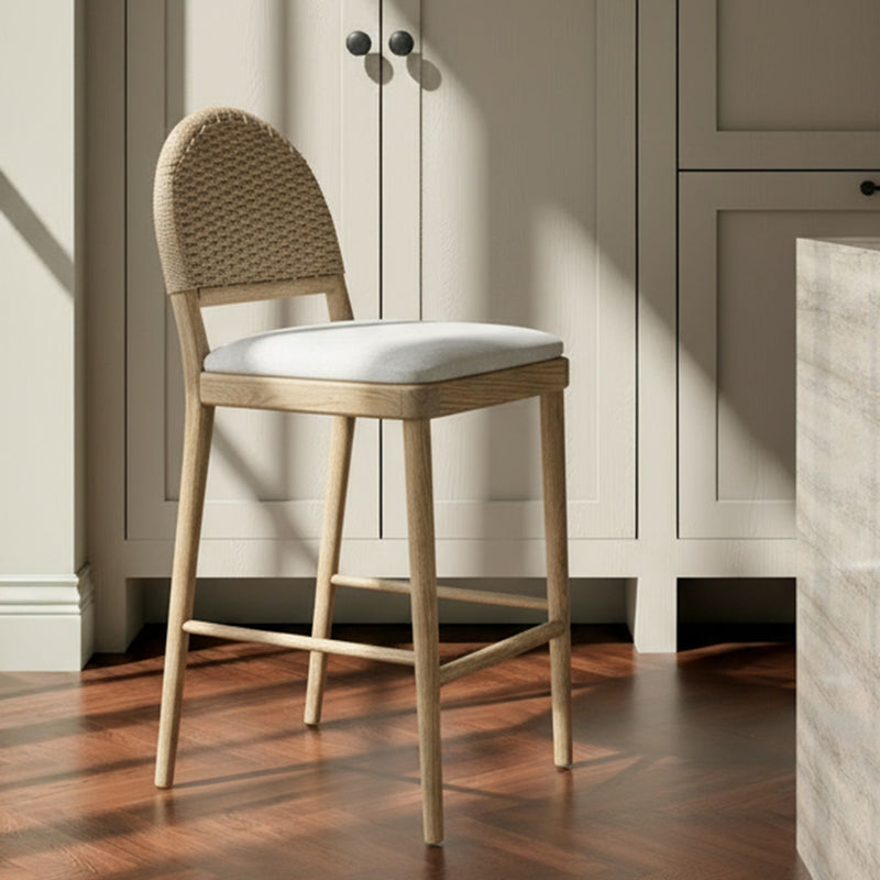 Counter stool with woven beige arched back, cushioned seat, natural wood legs
