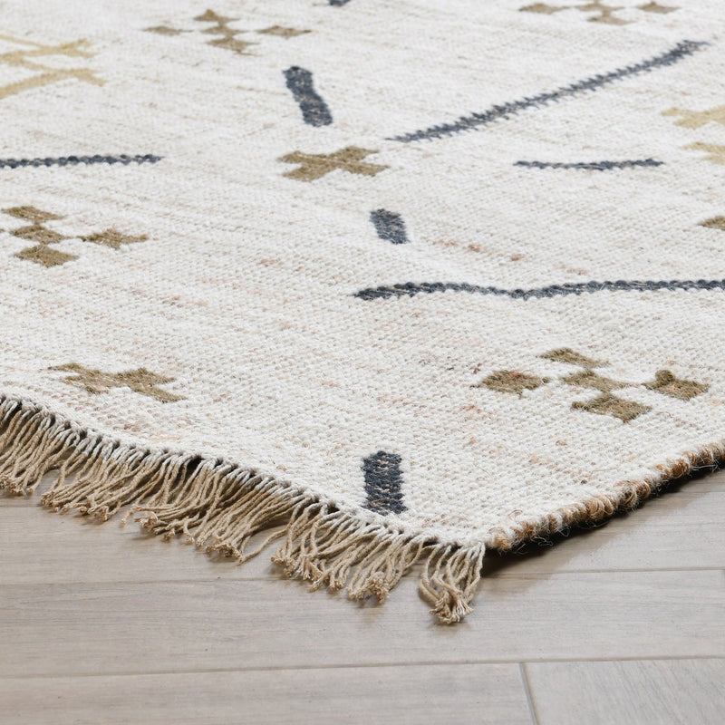 Ivory area rug with dark blue geometric motifs and short knotted fringe