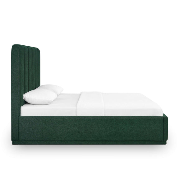 Dark green upholstered bed with two white pillows and smooth upholstered side rail.