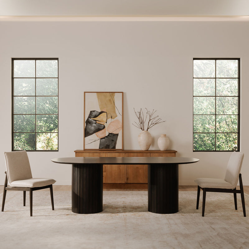 Set of two beige dining chairs with dark legs and upholstered backs beside table
