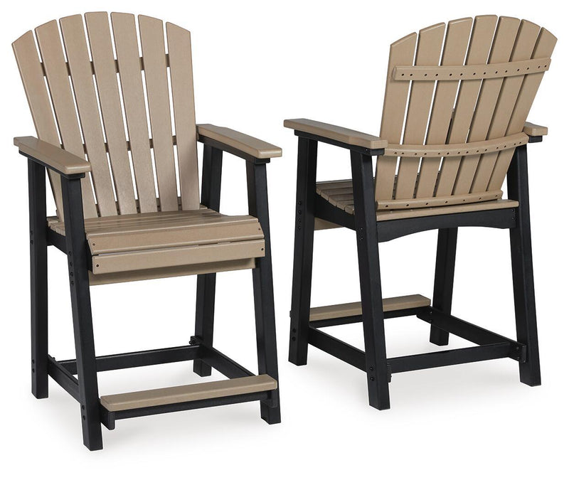 Pair of barstools showing driftwood slatted back, armrests, and black footrest