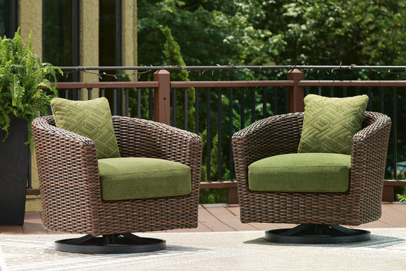 Swivel lounge chairs with green cushions and dark brown wicker, shown as a pair