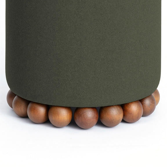 Close-up of dark green ottoman fabric and wooden ball base